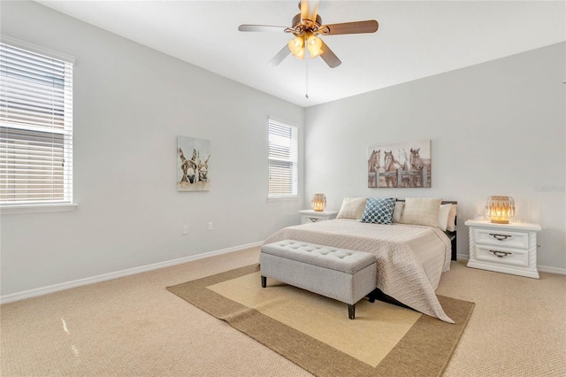 bedroom featuring baseboards, light colored carpet, and a ceiling fan