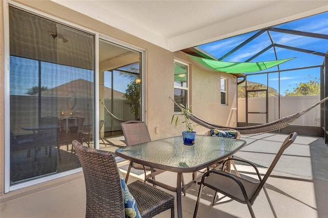 view of patio featuring glass enclosure and outdoor dining area