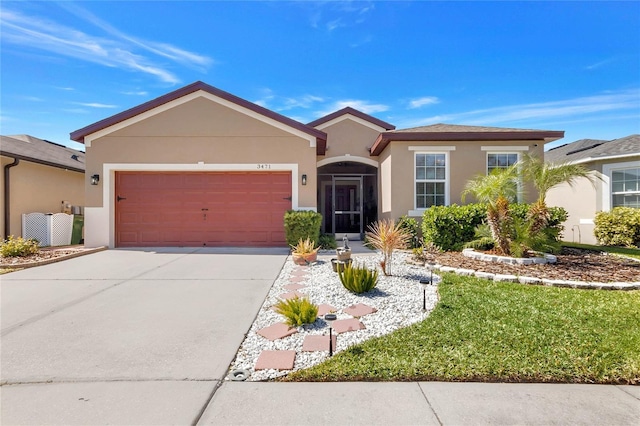 single story home with concrete driveway, an attached garage, and stucco siding