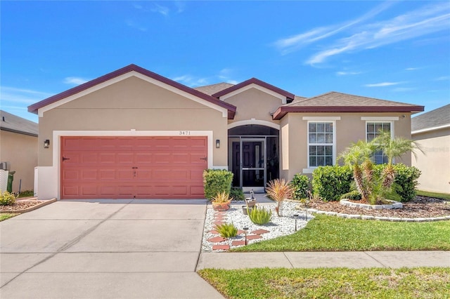 view of front of house with an attached garage, driveway, and stucco siding