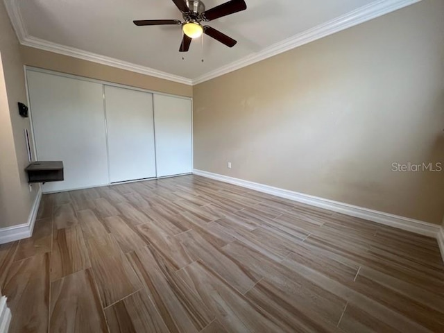 unfurnished bedroom with crown molding, baseboards, and wood finished floors