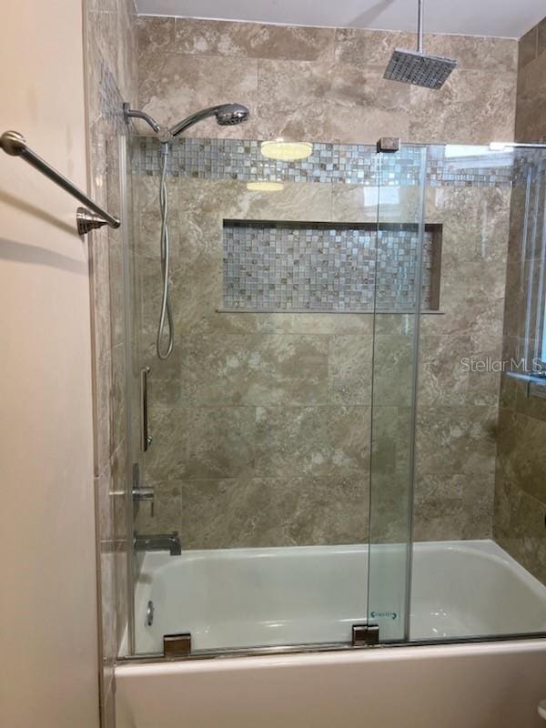 bathroom featuring a combined bath / shower with rainfall shower