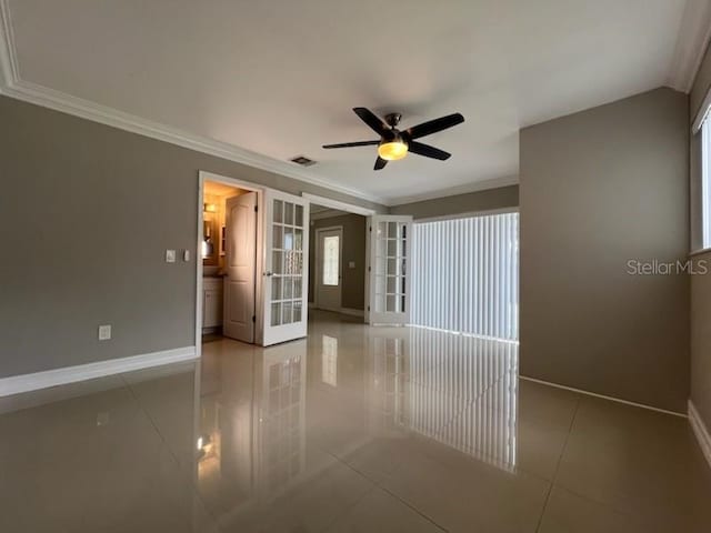 tiled empty room with ornamental molding, french doors, visible vents, and baseboards