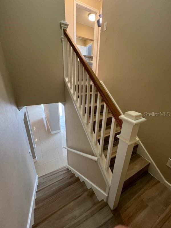 stairway featuring baseboards and wood finished floors