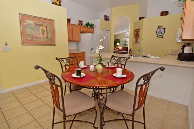 dining space featuring baseboards and light tile patterned flooring