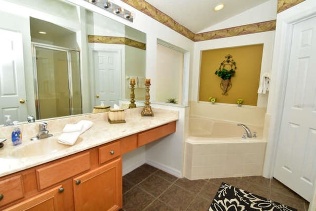 bathroom featuring lofted ceiling, a garden tub, vanity, tile patterned floors, and a stall shower