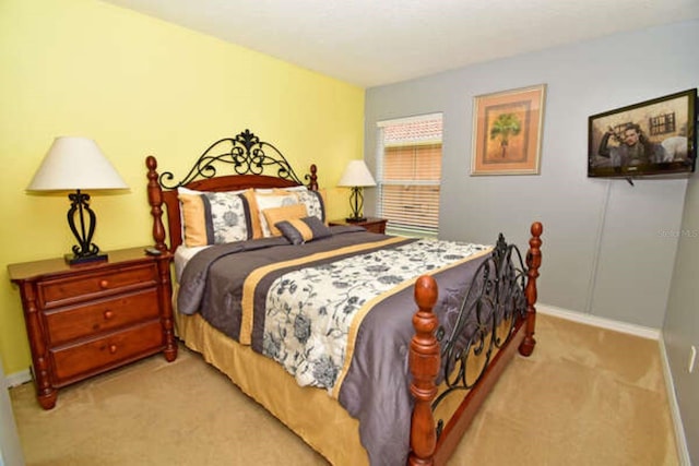 bedroom featuring light carpet and baseboards