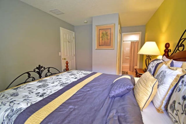 bedroom with visible vents and connected bathroom