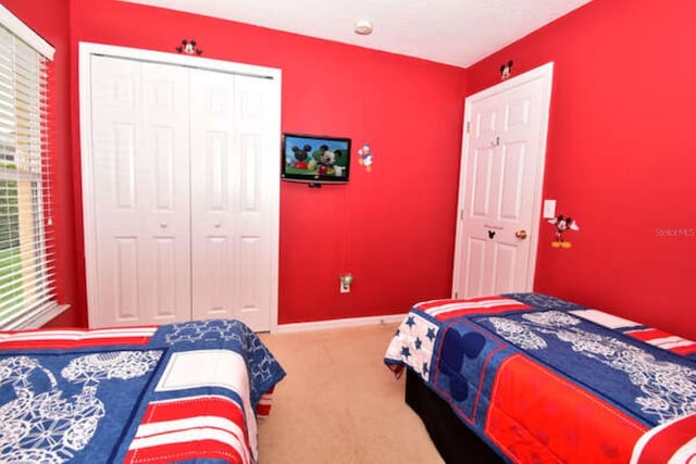 carpeted bedroom with baseboards and a closet