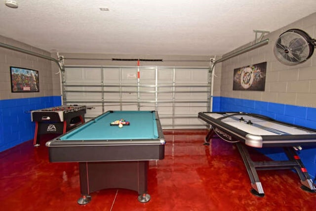 game room with a garage, billiards, concrete flooring, and concrete block wall