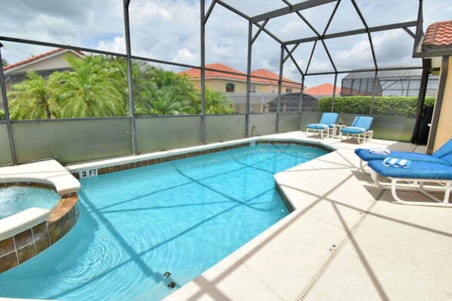 view of pool featuring a pool with connected hot tub, a lanai, and a patio