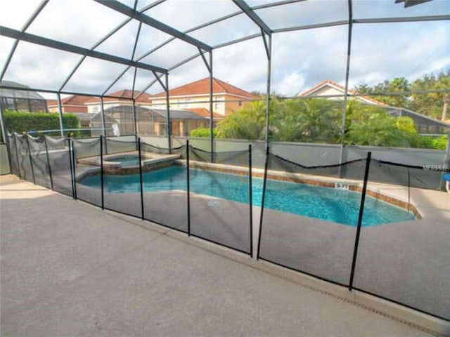 view of swimming pool featuring a lanai, a patio area, and a pool with connected hot tub