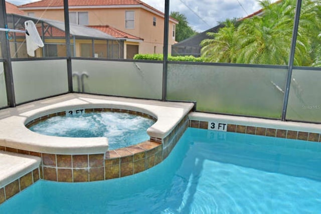 pool featuring a lanai and an in ground hot tub