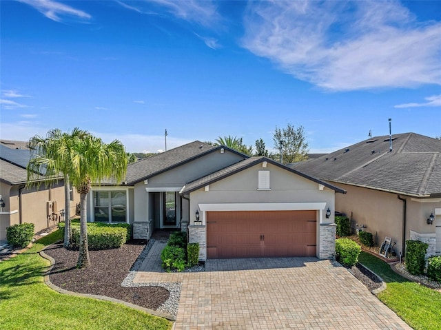 single story home featuring a garage, stone siding, decorative driveway, and stucco siding