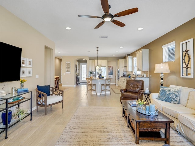 living room with plenty of natural light, visible vents, arched walkways, and recessed lighting