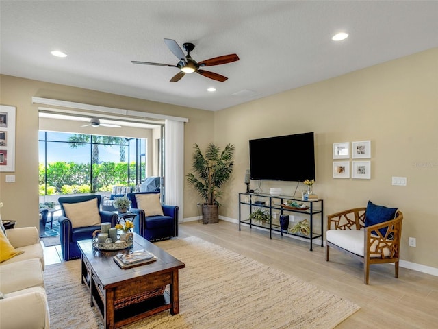 living room featuring light wood-type flooring, ceiling fan, baseboards, and recessed lighting