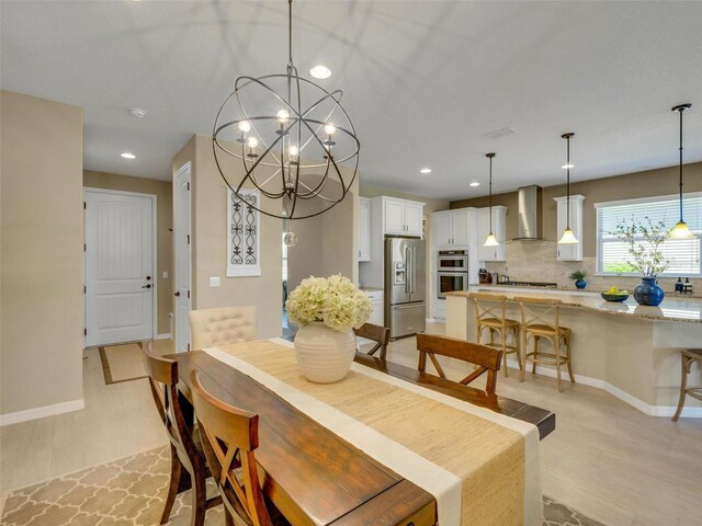 dining room with baseboards, light wood finished floors, a chandelier, and recessed lighting