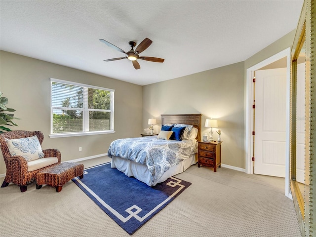 carpeted bedroom featuring a textured ceiling, baseboards, and a ceiling fan