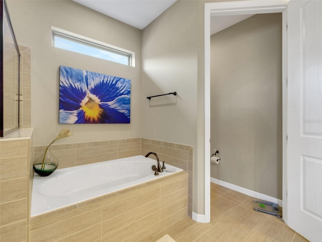 bathroom with baseboards, a bath, and tile patterned floors