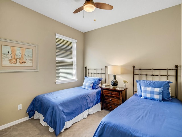 carpeted bedroom with ceiling fan and baseboards