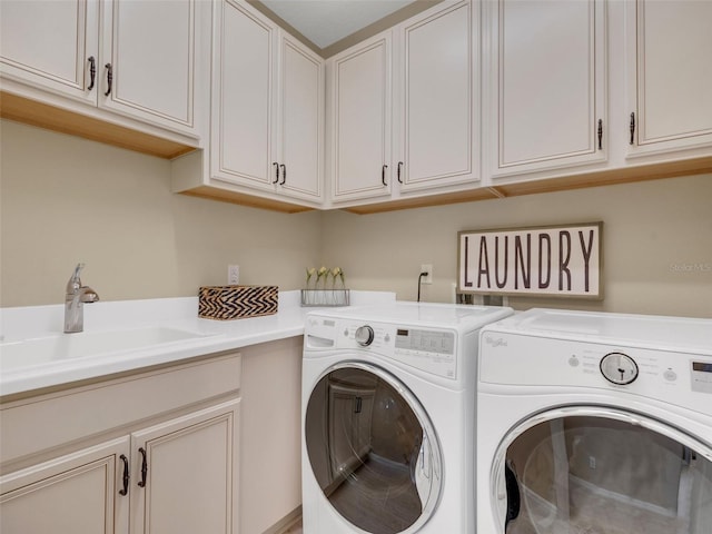 laundry area with cabinet space, a sink, and washing machine and clothes dryer