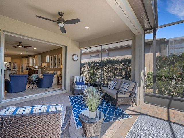 sunroom / solarium featuring a ceiling fan