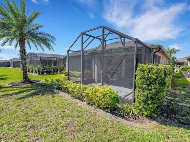 back of property with glass enclosure and a yard