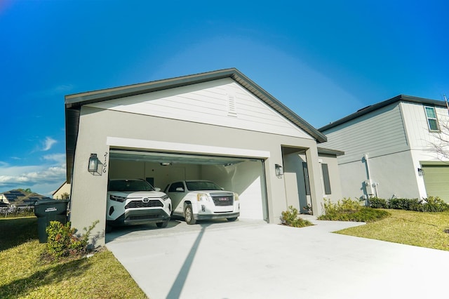 view of front of property featuring a garage, a front lawn, concrete driveway, and stucco siding