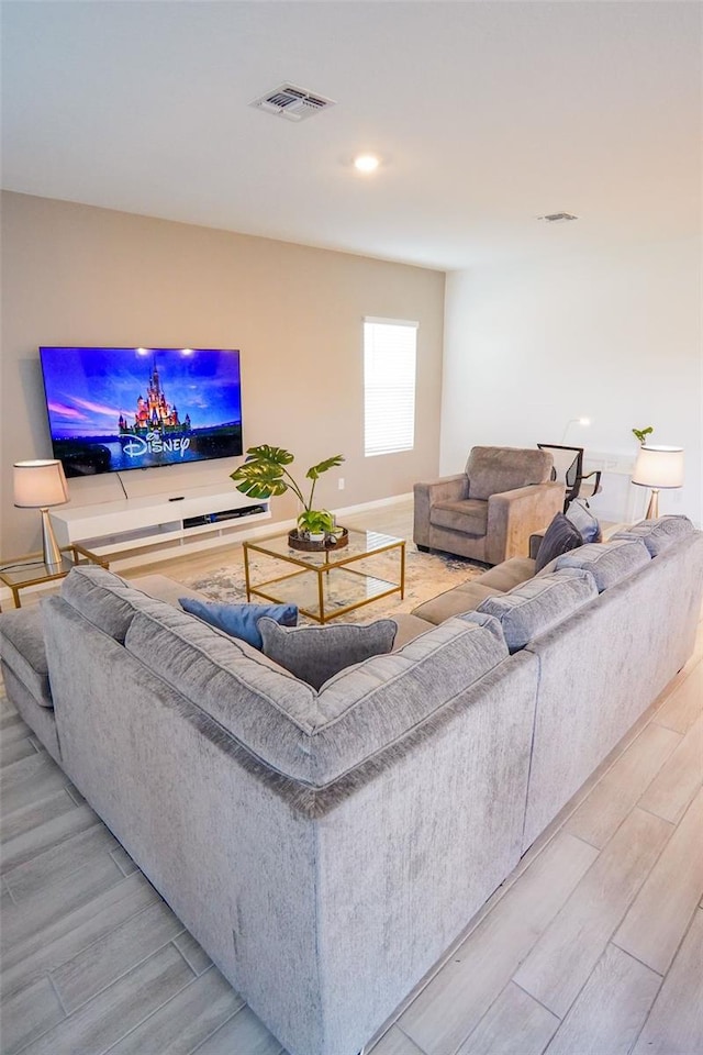 living area with light wood-type flooring and visible vents