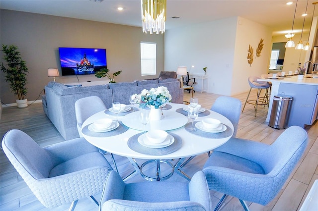 dining area featuring light wood-style floors, an inviting chandelier, and recessed lighting