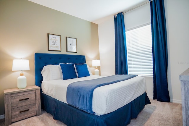 carpeted bedroom featuring multiple windows and baseboards