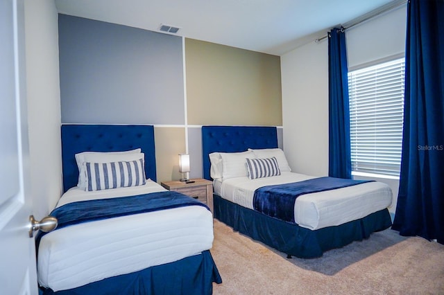 carpeted bedroom featuring visible vents