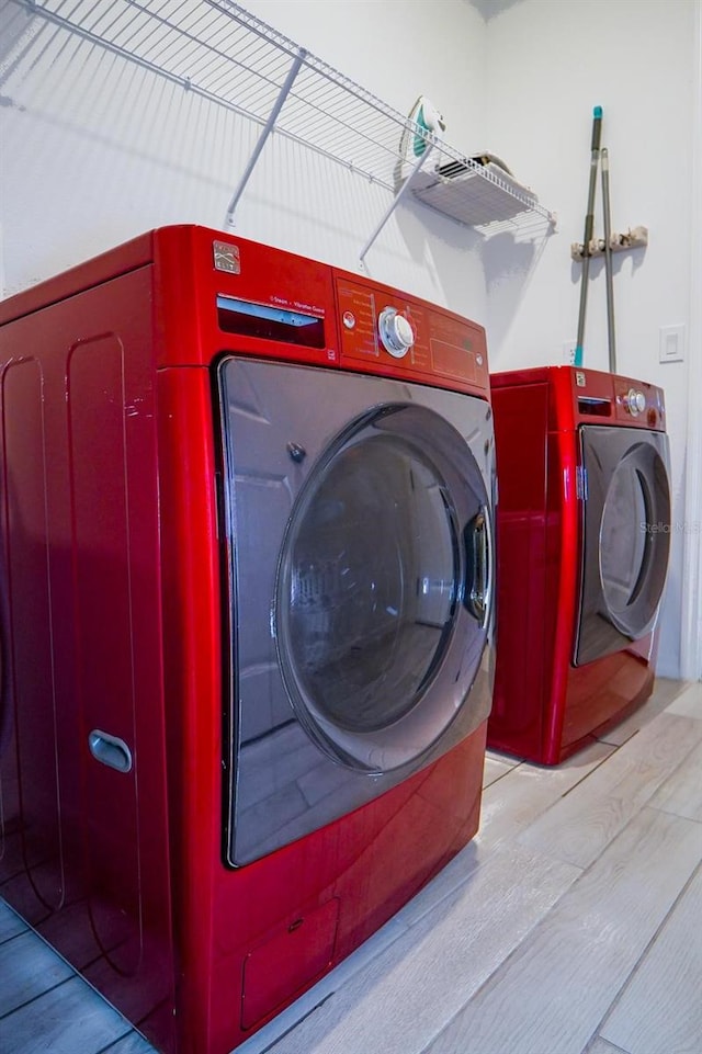 laundry area featuring laundry area, light wood finished floors, and washer and dryer