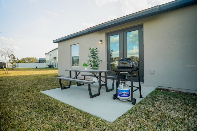 view of patio with a grill, fence, and french doors