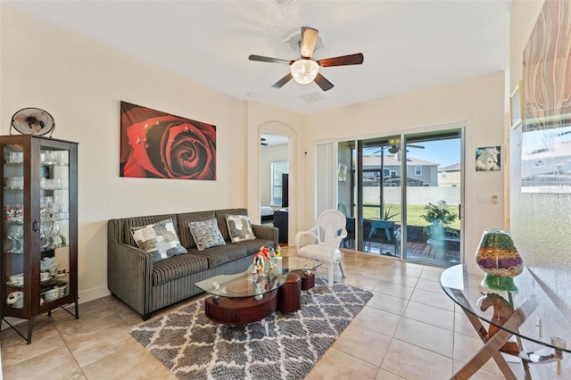 living area with visible vents, arched walkways, ceiling fan, and tile patterned flooring