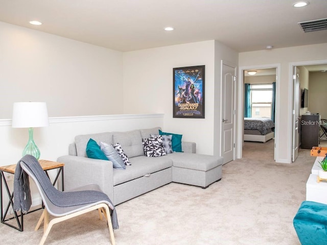 carpeted living area with visible vents and recessed lighting