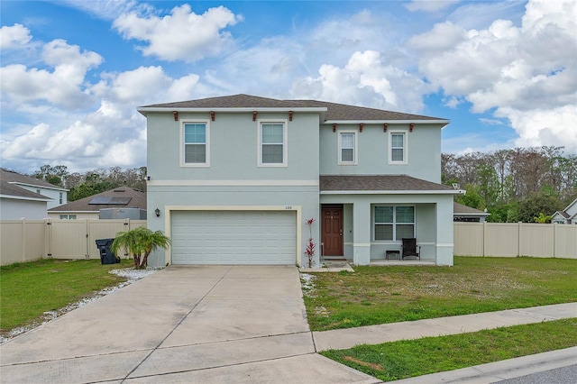 traditional-style home featuring an attached garage, a front yard, fence, and stucco siding