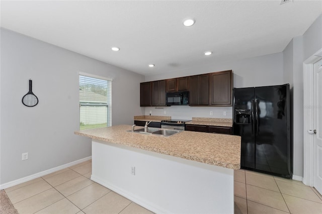 kitchen featuring light tile patterned floors, light countertops, dark brown cabinets, black appliances, and a sink