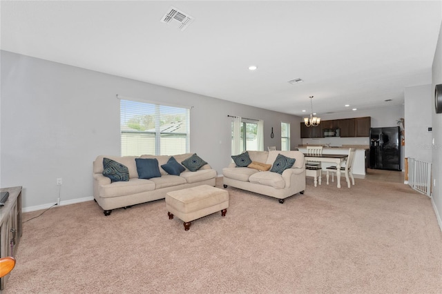 living room featuring light colored carpet, visible vents, a notable chandelier, and recessed lighting