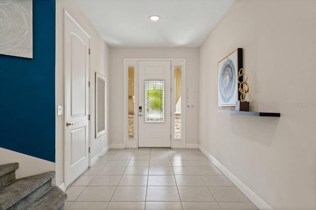 entryway featuring stairway, baseboards, and light tile patterned floors