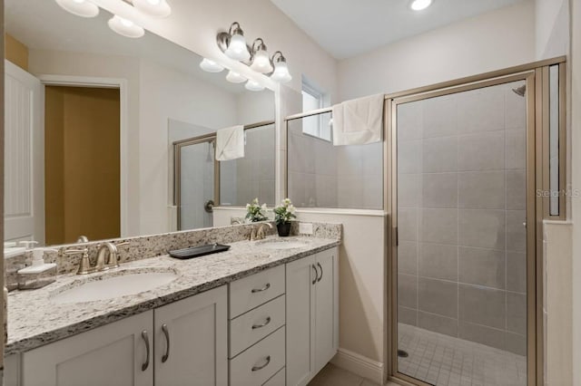 full bathroom featuring double vanity, a stall shower, and a sink