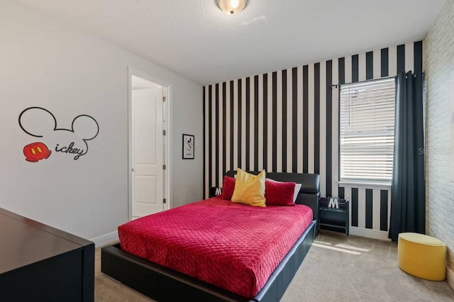 carpeted bedroom featuring baseboards, an accent wall, and wallpapered walls