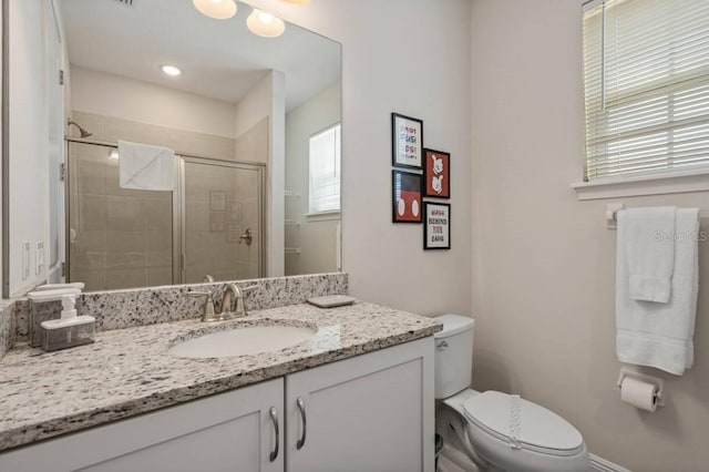 bathroom with toilet, a shower stall, and vanity