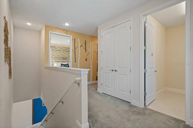 hallway with baseboards, carpet, an upstairs landing, and recessed lighting