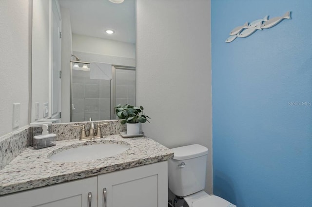 full bathroom featuring vanity, a shower stall, and toilet