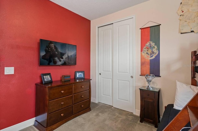 bedroom featuring a closet, carpet flooring, and baseboards