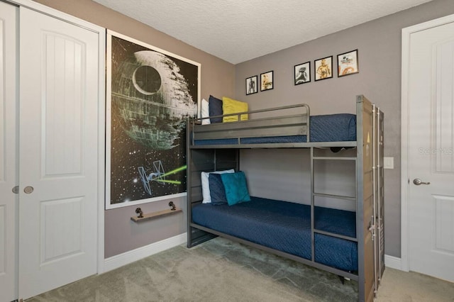 carpeted bedroom featuring a textured ceiling and baseboards