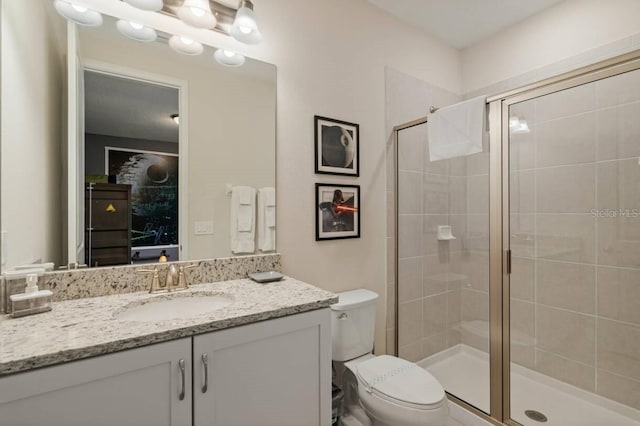 full bath featuring a stall shower, vanity, and toilet