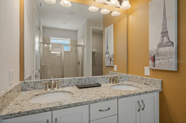 bathroom featuring double vanity, a sink, and a shower stall