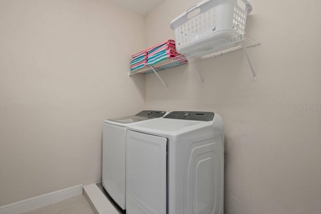 laundry room featuring washing machine and dryer, laundry area, and baseboards